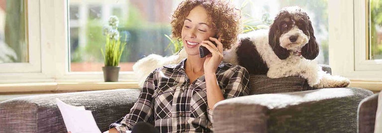 Women smiling on phone looking at laptop